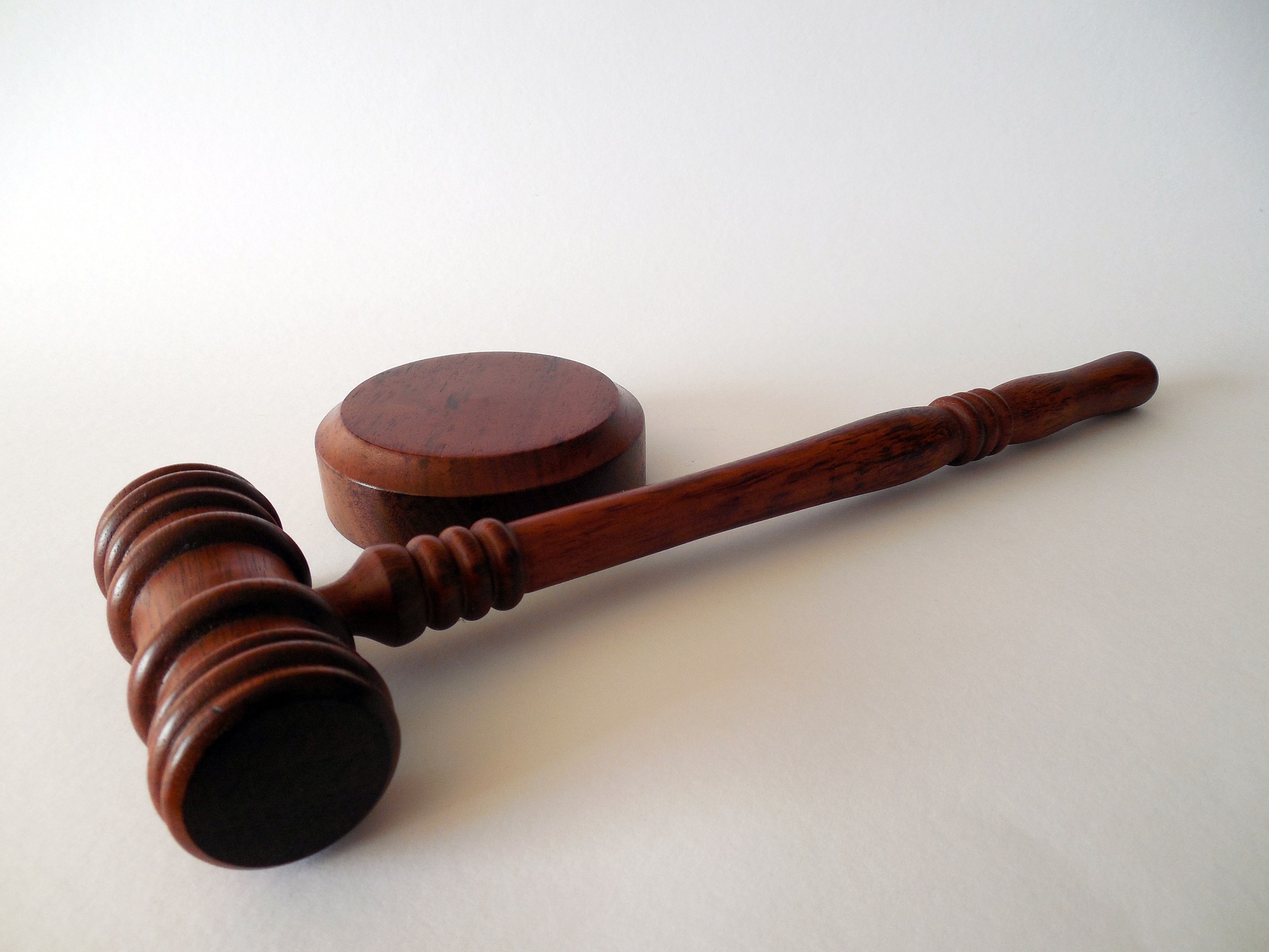 A wooden gavel and sound block, often symbols in cases involving DUI in Pennsylvania, are displayed on a white background. The gavel, used by judges and auctioneers, has a cylindrical head and handle, while the sound block is a small round platform designed for it to strike.