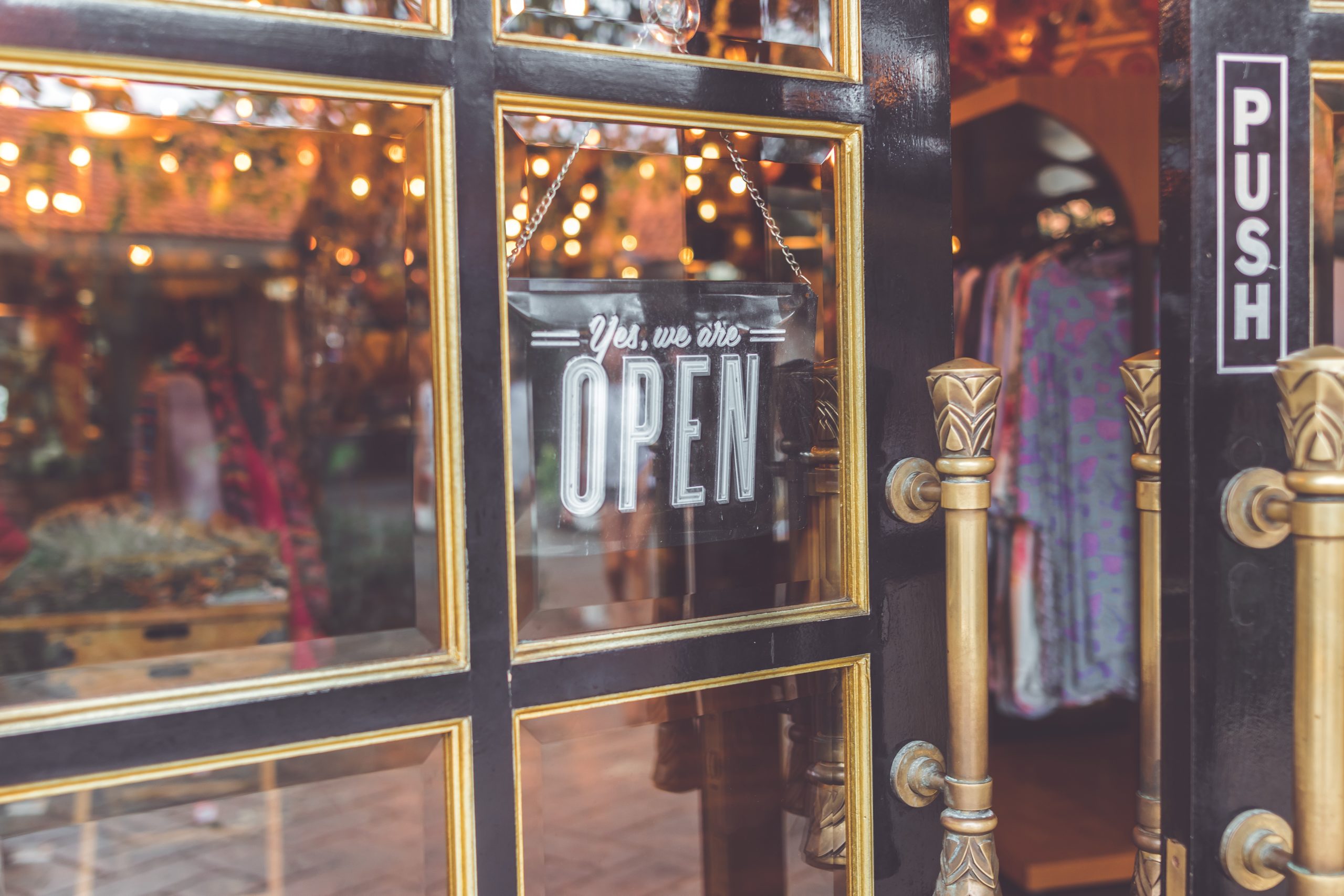 A storefront door with a sign that reads,