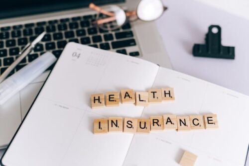 health insurance spelled out on notebook