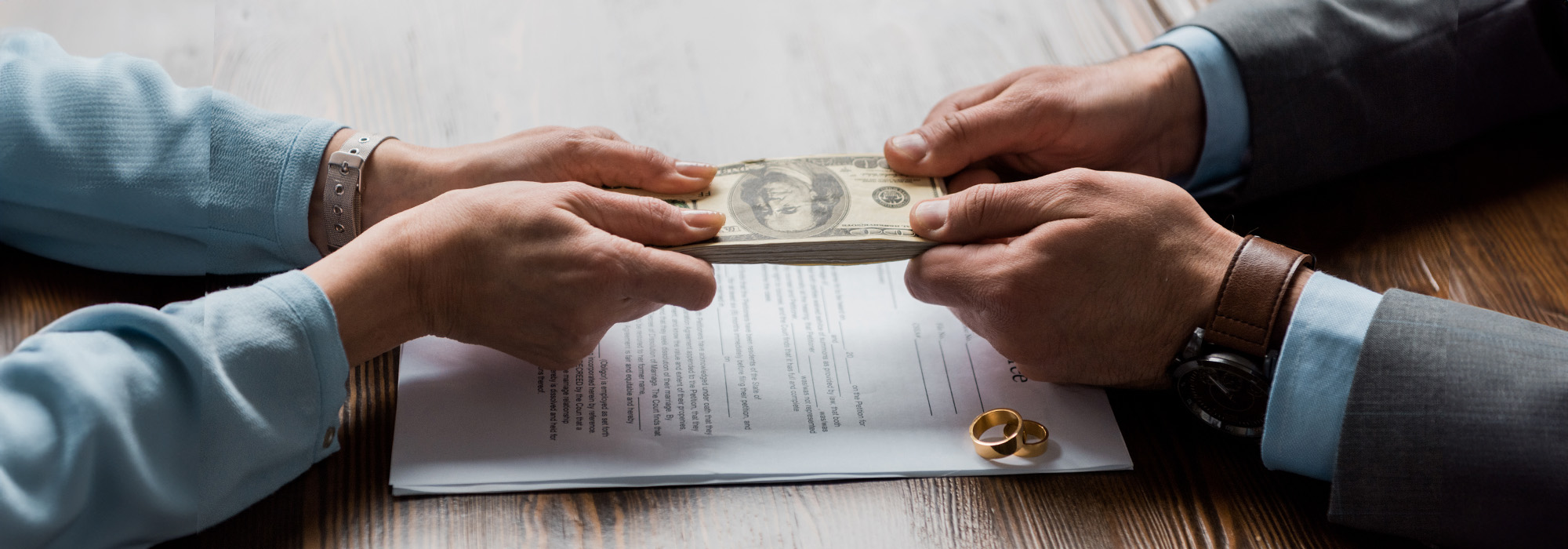 lawyer and client holding dollar banknotes above divorce decree