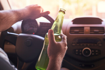 man drinking beer in car