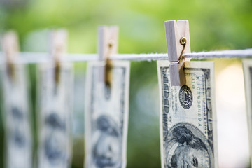 dollar bills hung on a laundry line