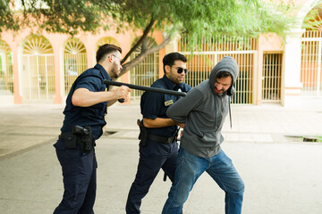 two police officers and man resisting arrest