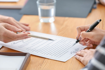 people signing prenuptial agreement