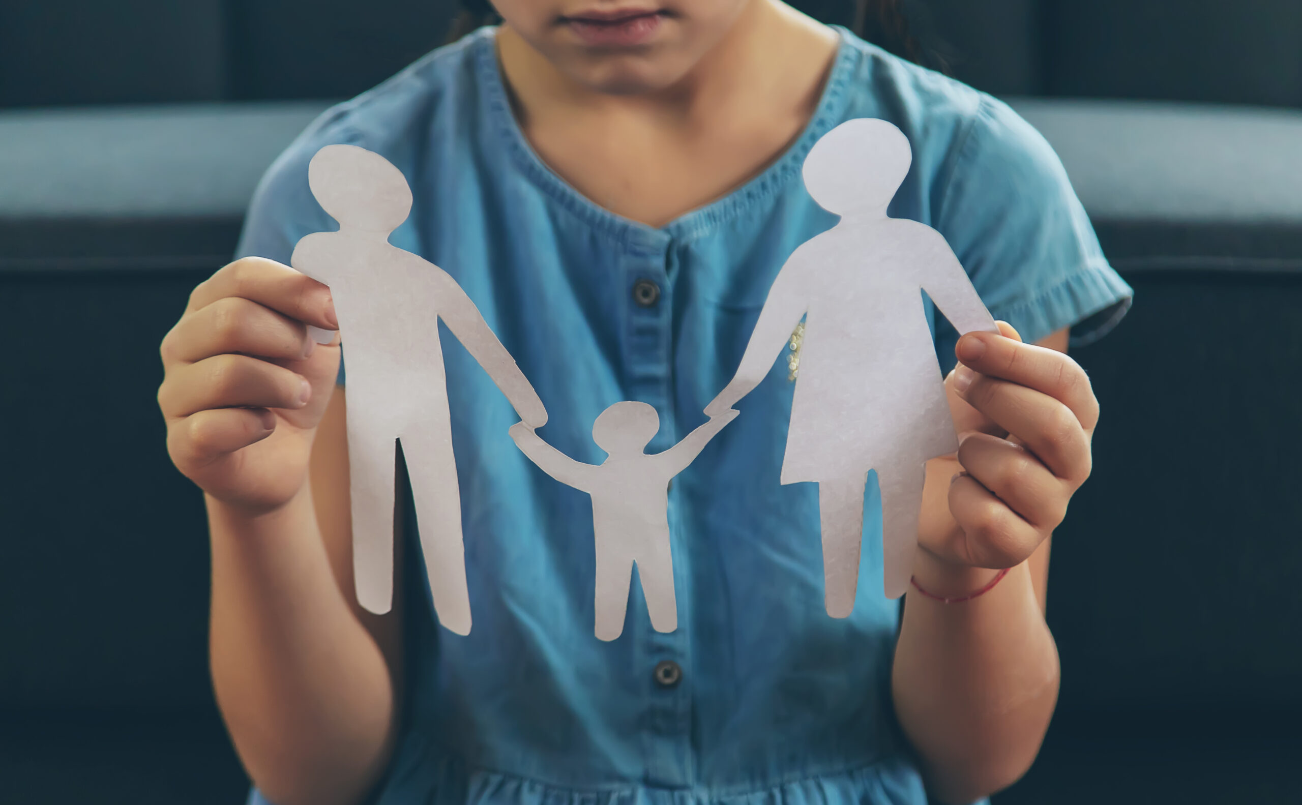 child holding cutout of family